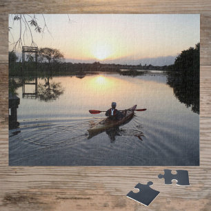 Kayaker op het rustige water van het meer bij zons legpuzzel