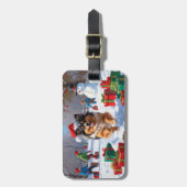 Keeshond-hond loopt in de sneeuw met kerstmuts bagagelabel (Voorkant verticaal)