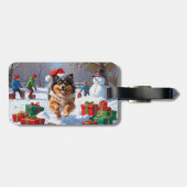 Keeshond-hond loopt in de sneeuw met kerstmuts bagagelabel (Achterkant horizontaal)