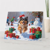 Keeshond-hond loopt in de sneeuw met kerstmuts kaart (Voorkant)