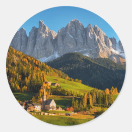 Kerk en dorp met berglandschap ronde sticker