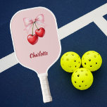 Kersenboog roze naam pickleball paddle<br><div class="desc">Rode kersen met roze strik. Zacht roze achtergrond. Personaliseer en voeg jouw naam toe.</div>