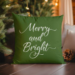 Kerstavond en helder rood groen kussen<br><div class="desc">Omkeerbaar minimaal ontwerp met "Merry and Bright" in moderne witte script-typografie tegen een bosgroene achtergrond aan de ene kant en een rode achtergrond tegen het vuur aan de andere kant.</div>