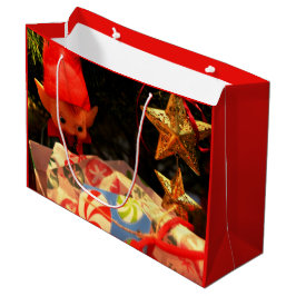 Kerstelf onder de kerstboom cadeautas