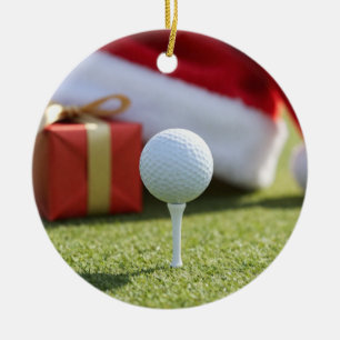 Kerstgolfbal met kerstmuts op tee op gras keramisch ornament