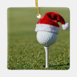 Kerstgolfbal met kerstmuts op tee op gras keramisch ornament
