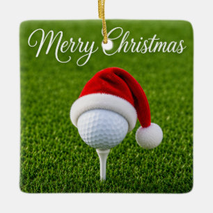 Kerstgolfbal met kerstmuts op tee op groen gras keramisch ornament