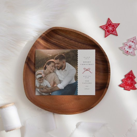 Kerstkaart met golvende rand en rode strik foto