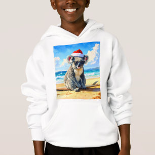 Kerstkoala met kerstmuts op het zonnige zandstrand