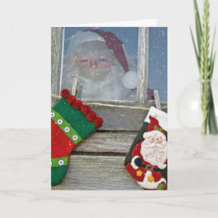 Kerstman in hutvenster met sneeuwvlokken kaart