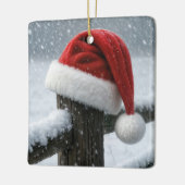 Kerstmannenhoed op een besneeuwde omheiningspaal keramisch ornament (Links)