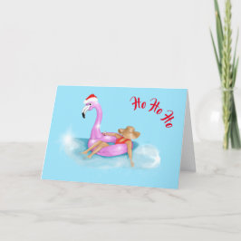 Kerstmannenhoed op een roze flamingo-vlot vakantie kaart