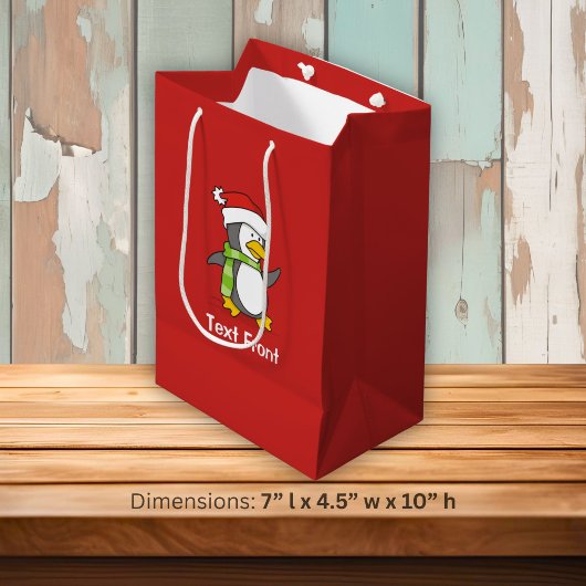 Kerstpinguïn die over sneeuw loopt medium cadeauzakje