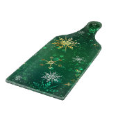 Kerstsneeuwvlokken op groene achtergrond snijplank (Hoek)