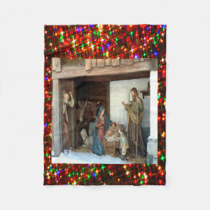 Kerststal in dorp onder baldakijn met meerkleuren fleece deken