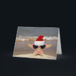 Kerststerren op vakantie feestdagen kaart<br><div class="desc">Starfish met een gestreepte bikini en Santa hat op een strand.</div>