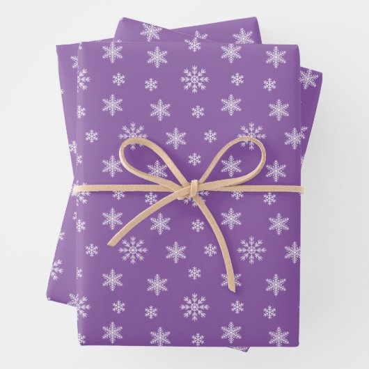 Kerstwitte sneeuwvlokken op paarse achtergrond inpakpapier vel (In situ)