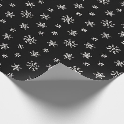 Kerstwitte sneeuwvlokken op zwarte achtergrond cadeaupapier (Hoek)