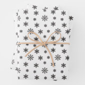 Kerstzwarte sneeuwvlokken op witte achtergrond inpakpapier vel (In situ)