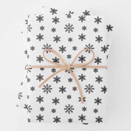 Kerstzwarte sneeuwvlokken op witte achtergrond inpakpapier vel (In situ)