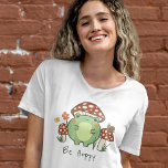 Kikker en paddenstoelen zijn haverige Cartoon T-shirt<br><div class="desc">Dit schattige T-shirt is voorzien van een handgetekende kawaï-achtige cartoon kikker met een paddenstoeltje pet, samen met andere paddenstoelen, een slak, een bloem, een vlinder en gras. Een kleurenschema van rood, limoen, groen, bruin, oranje, geel en perzikkleurig is ideaal voor het esthetische liefhebber van de Kern van Indie of van...</div>