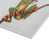 Kikte groene kikker met oogbril op wit snijplank (Hoek)