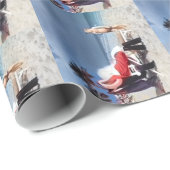 Kind kijkt naar de kerstman die op strand zit cadeaupapier (Rol Hoek)