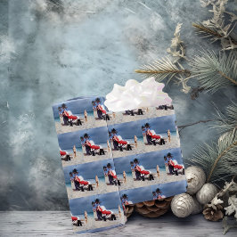 Kind kijkt naar de kerstman die op strand zit cadeaupapier