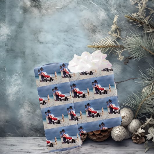 Kind kijkt naar de kerstman die op strand zit cadeaupapier