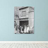 Kinderen buiten de werkplaats van John Pounds Canvas Afdruk (Insitu (Houten vloer))