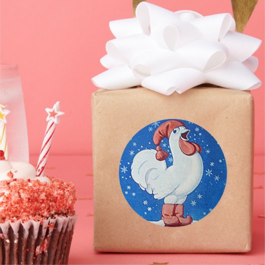 Kip in rood pet zingt in label met kerstsneeuw (Feest)