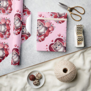 Kitten zitten in een doos met bloemen en geschenke cadeaupapier