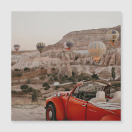 Klassieke rode auto die warme luchtballonnen kijk