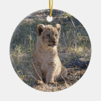 Kleine Afrikaanse leeuwenwelp zittend in het gras Keramisch Ornament