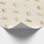 Kleine gouden krabben op een gebroken wit cadeaupapier (Hoek)
