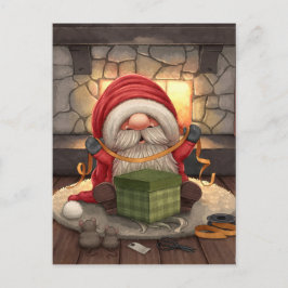 Kleine kerstman die een cadeau inpakt briefkaart