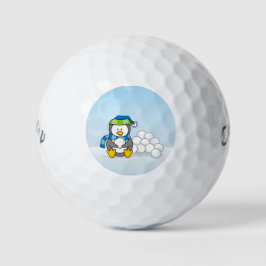 Kleine pinguïn die zit met sneeuwballen golfballen