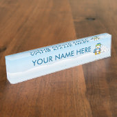 Kleine pinguïn die zit met sneeuwballen naambordje (Zijkant)