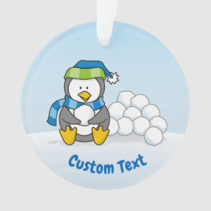 Kleine pinguïn zit met sneeuwballen ornament
