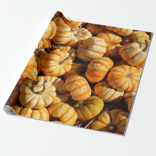 kleine pompoenen in de stapel cadeaupapier