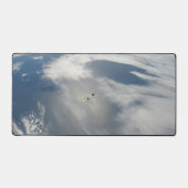 Kleine satellieten draaien boven een deel van de a bureaumat (Voorkant)