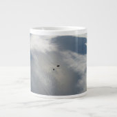 Kleine satellieten draaien boven een deel van de a grote koffiekop (Voorkant)