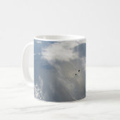 Kleine satellieten draaien boven een deel van de a koffiemok (Voorkant links)