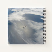 Kleine satellieten draaien boven een deel van de a notitieboek (Achterkant)