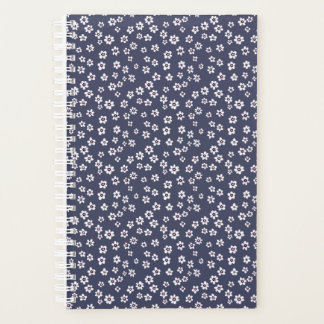 Kleine witte bloemen op een blauwe planner