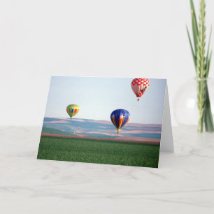 Kleinere heteluchtballonnen drijven boven tarwe feestdagen kaart