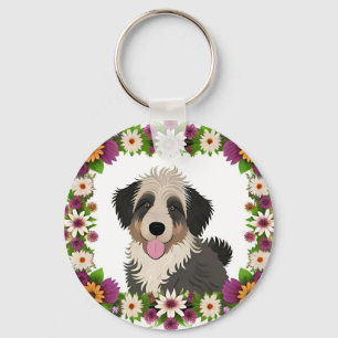 Kleurrijk bloemenkader met illustratie van een sch sleutelhanger