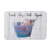 Kleurrijk gevouwen wasgoed op hanen in een blauwe  badmat (Voorkant)