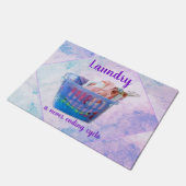 Kleurrijk gevouwen wasgoed op hanen in een blauwe  deurmat (Schuin)