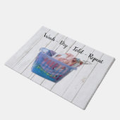 Kleurrijk gevouwen wasgoed op hanen in een blauwe deurmat (Schuin)